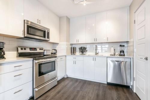 a kitchen with white cabinets and stainless steel appliances at Pet-Friendly Spacious condos in Downtown New Orleans in New Orleans