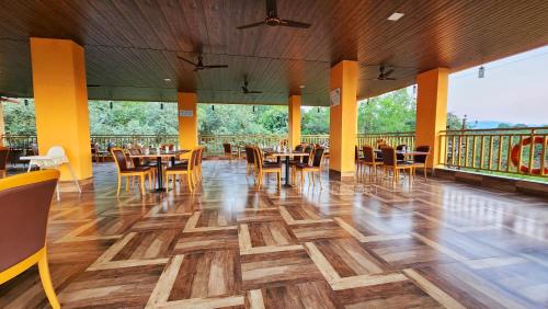 a restaurant with wooden floors and tables and chairs at MAP RESORT in Alibaug