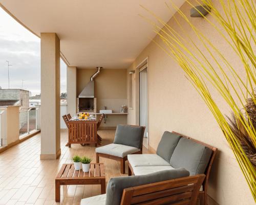 un soggiorno con divano e sedie su un balcone di Casa Massima Suites a Casamassima