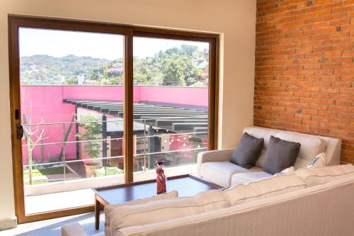 a living room with a couch and a brick wall at Casa de la Ballena in Sayulita