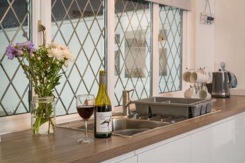 uma garrafa de vinho e um copo com flores no balcão em Finest Retreats - Chantilly em Great Yarmouth