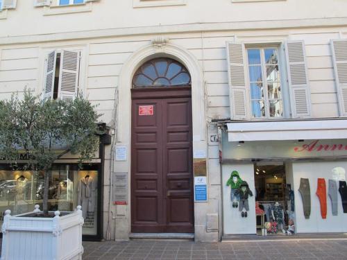 a building with a large brown door on a street at Appartements Nice Centre Carré d’or in Nice