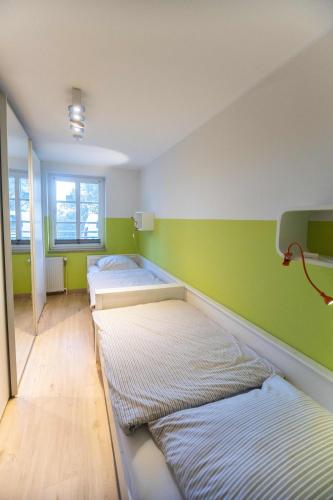 a room with two beds and a green wall at Ferienwohnung Merle in Wyk auf Föhr