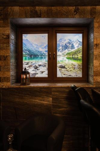 a window with a view of a lake and mountains at Villa Magnat SPA, JACUZZI, SAUNA, TĘŻNIA SOLANKOWA in Białka Tatrzanska