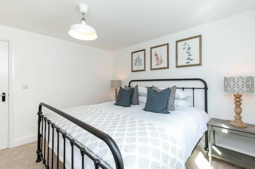 a bedroom with a white bed with blue pillows at Oxfordshire Living - The Sunderland Apartment - Bladon in Bladon