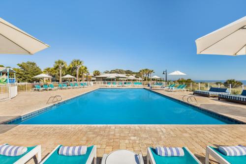 a swimming pool with lounge chairs in a resort at Holiday Inn Resort Jekyll Island, an IHG Hotel in Jekyll Island