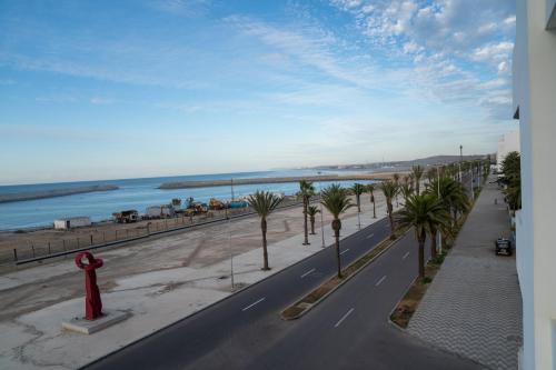a street with palm trees and a red fire hydrant at PUERTO MARINA ASILAH in Asilah