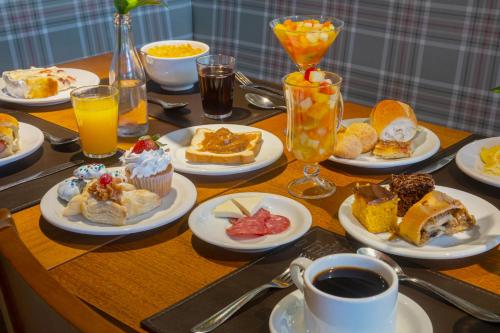 Hotel Laghetto Vivace في كانيلا: طاولة تعلوها أطباق من أطعمة الإفطار والمشروبات