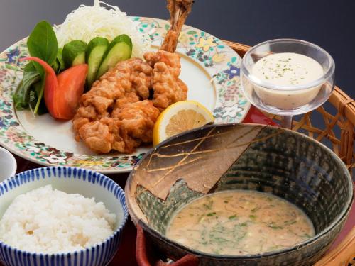 a table with a plate of food and a bowl of rice at Tokiwaso in Miyakonozyō
