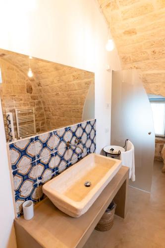 a bathroom with a sink and blue and white tiles at Masseria Parco della Grava in Pezze di Greco