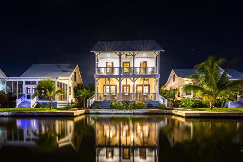 a house at night with its reflection in the water at Casa Blanca and The PoolClub at Mahogany Bay in San Pedro