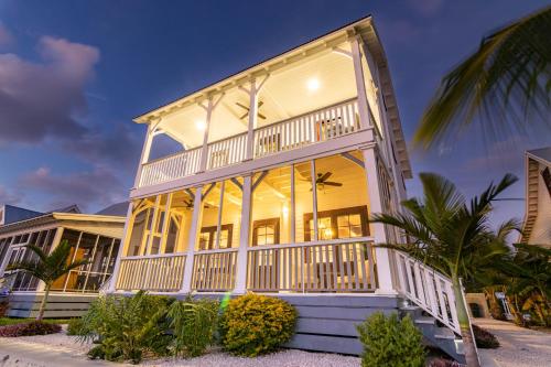 a large white house with a balcony at Casa Blanca and The PoolClub at Mahogany Bay in San Pedro