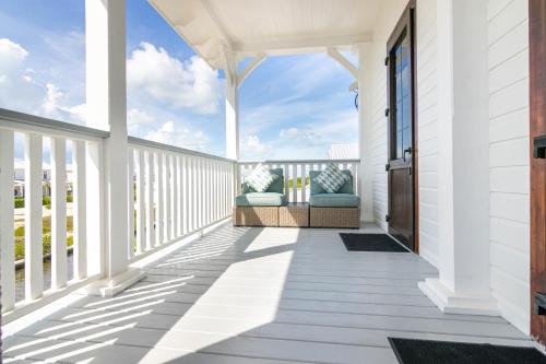 a white porch with two chairs on it at Casa Blanca and The PoolClub at Mahogany Bay in San Pedro
