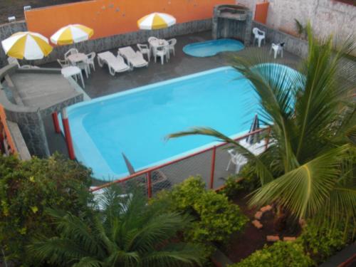 an overhead view of a swimming pool with tables and umbrellas at Pousada Sol Nascente in Olímpia