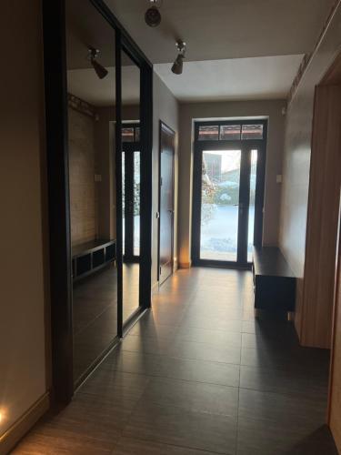 an empty hallway with glass doors and tile floors at Boutique Guest House in Liepāja