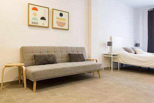 ein Wohnzimmer mit einem Sofa und einem Bett in der Unterkunft Apartamento Málaga Marmoles 2 in Málaga
