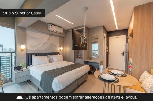 a hotel room with a bed and a table at Charlie Vitrali Moema in São Paulo