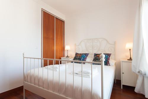 1 dormitorio con 1 cama con marco blanco en FLH Expo Cozy Apartment, en Lisboa