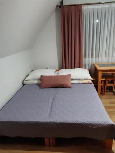 łóżko w pokoju z oknem w obiekcie Pokoje u Lusi w mieście Białka Tatrzanska