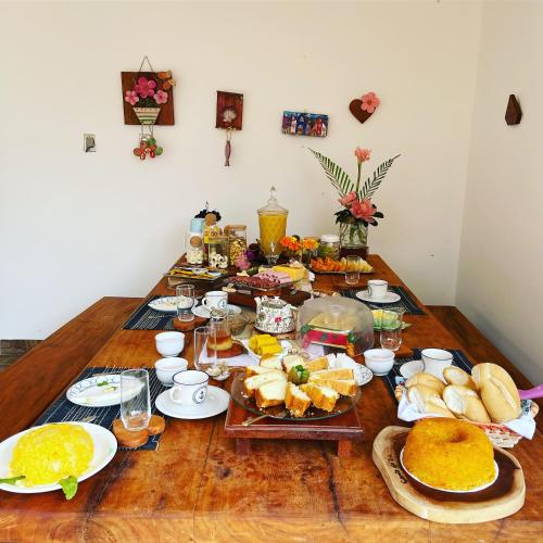 Pousada Canto de Zul في إيتاكاري: طاولة مليئة بالطعام على طاولة خشبية