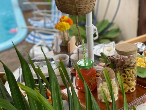 Pousada Canto de Zul في إيتاكاري: طاولة مغطاة بأطباق الطعام والنباتات الخضراء