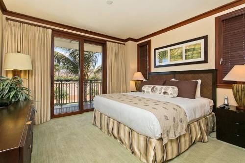 a bedroom with a large bed and a balcony at Ko Olina Beach Villas O410 - 2BR Luxury Condo with Partial Ocean View in Kapolei
