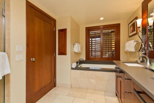 a bathroom with a sink and a bath tub at Ko Olina Beach Villas O410 - 2BR Luxury Condo with Partial Ocean View in Kapolei