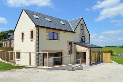 a house under construction with a black roof at The Farmhouse at Williamscraig Holiday Cottages in Linlithgow