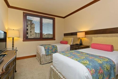 a hotel room with two beds and a desk at Ko Olina Beach Villas O512 - 2BR Ocean View Luxury Condo with Semi-Private Lagoon Beach & 1 Free Parking in Kapolei