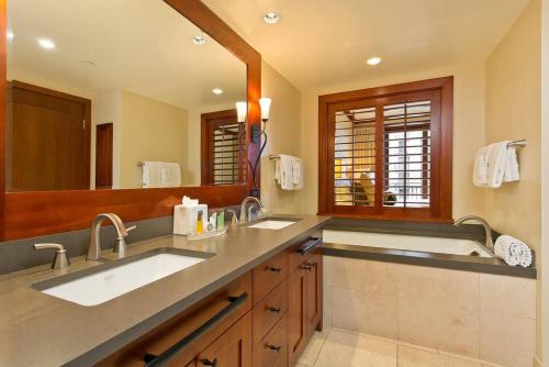 a bathroom with two sinks and a large mirror at Ko Olina Beach Villas O512 - 2BR Ocean View Luxury Condo with Semi-Private Lagoon Beach & 1 Free Parking in Kapolei