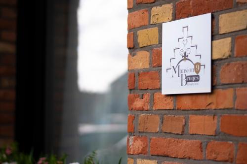 a sign on a brick wall at Mansion9Bruges in Bruges