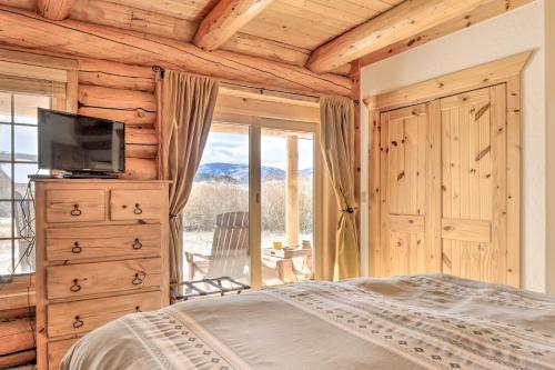 a bedroom with a bed and a tv and a window at Granby Home with Mountain Views and Fire Pit in Granby