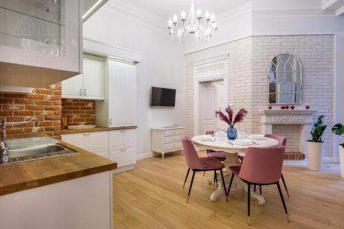 a kitchen and dining room with a table and chairs at Fragola Apartments Old Town in Krakow