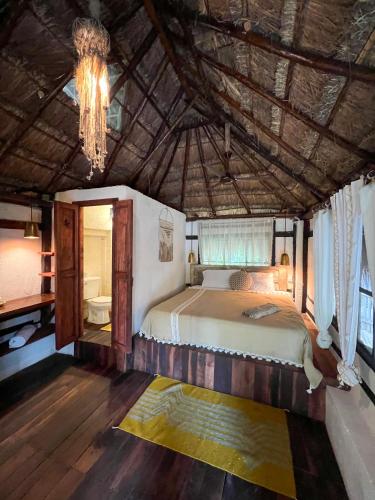 a bedroom with a bed and a chandelier at Villa Santuario Lake front Oasis in Bacalar