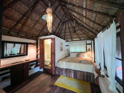 a bedroom with a bed and a desk and a tv at Villa Santuario Lake front Oasis in Bacalar