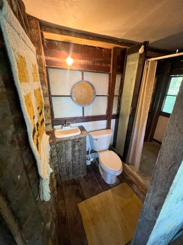 a small bathroom with a toilet and a sink at Villa Santuario Lake front Oasis in Bacalar