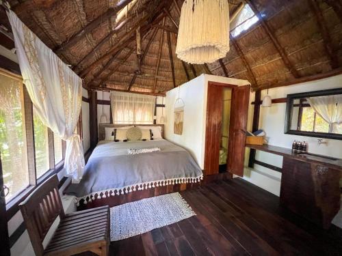 a bedroom with a bed in a room with windows at Villa Santuario Lake front Oasis in Bacalar
