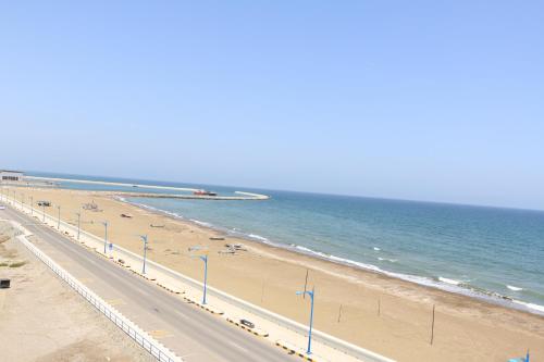 uma vista para uma praia com uma estrada e o oceano em Marina em Sohar