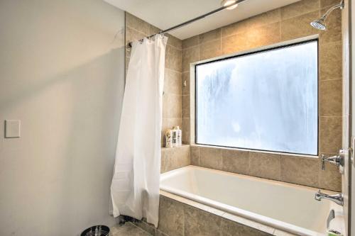 a bathroom with a bath tub and a window at Comfortable Dallas Condo Close to Attractions in Dallas