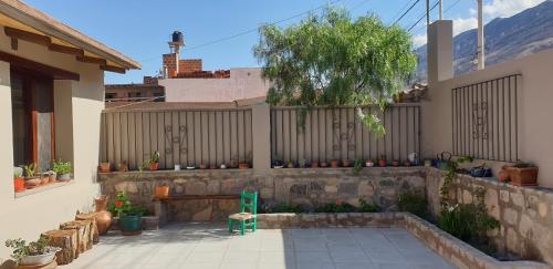 a patio with a bench and a fence with plants at La Casa de los Molles in Tilcara