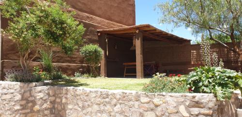 a house with a stone wall in front of a yard at La Casa de los Molles in Tilcara