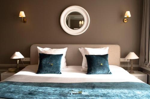 a bedroom with a bed with blue pillows and a mirror at Mansion9Bruges in Bruges