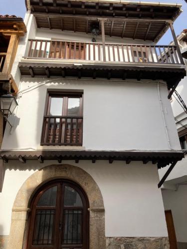 ein Gebäude mit einer Tür und einem Balkon in der Unterkunft CR "Calle Real" en la Sierra de Gredos in Villanueva de la Vera