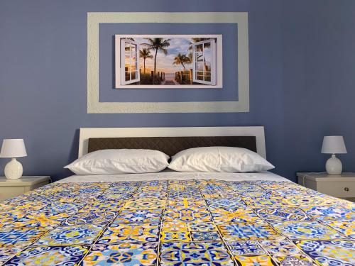 um quarto azul com uma cama com uma colcha colorida em Luna Blu Apartment em Palermo