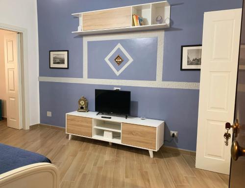 um quarto com uma televisão numa parede azul em Luna Blu Apartment em Palermo