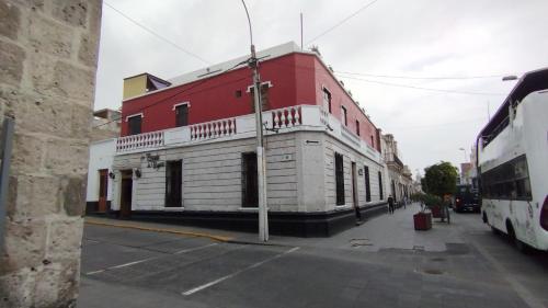 a red and white building on the side of a street at Hotel La Posada de Ugarte in Arequipa