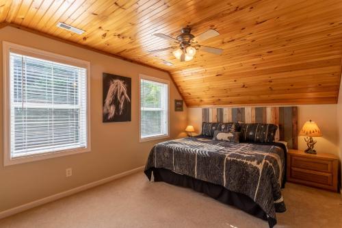 a bedroom with a ceiling fan and a bed at 4 Bears Lodge in Banner Elk