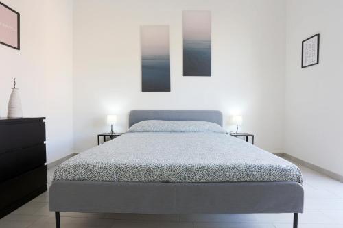 een slaapkamer met een bed en twee foto's aan de muur bij Bright & Central Apartment near the station in Salerno