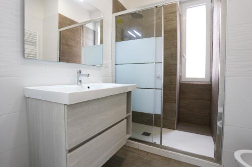 een badkamer met een wastafel en een douche bij Bright & Central Apartment near the station in Salerno