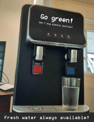 a black coffee maker with a glass of water at Moana Breeze Rangiroa - Rental car included - Air conditioning - WI-Fi in Tiputa